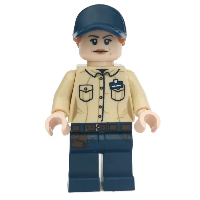 Une minifigurine LEGO en tenue, avec un casque bleu foncé, une chemise beige à boutons noirs et badge, et un pantalon bleu taché de terre.