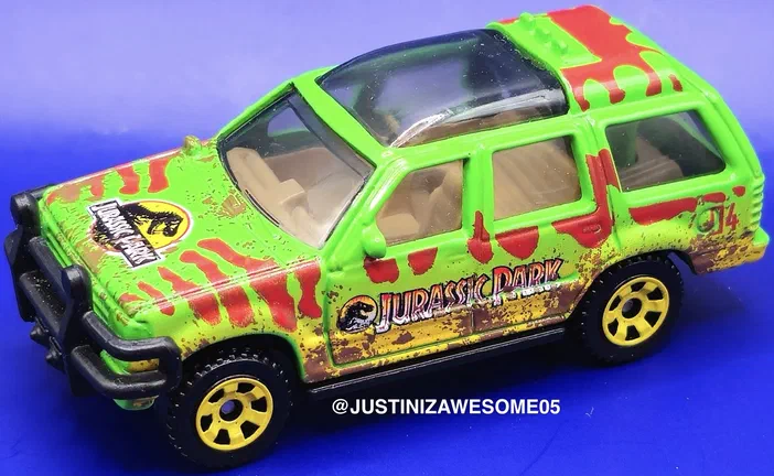 Voiture de jouy Matchbox verte et marron aux motifs du film Jurassic World Dominion.