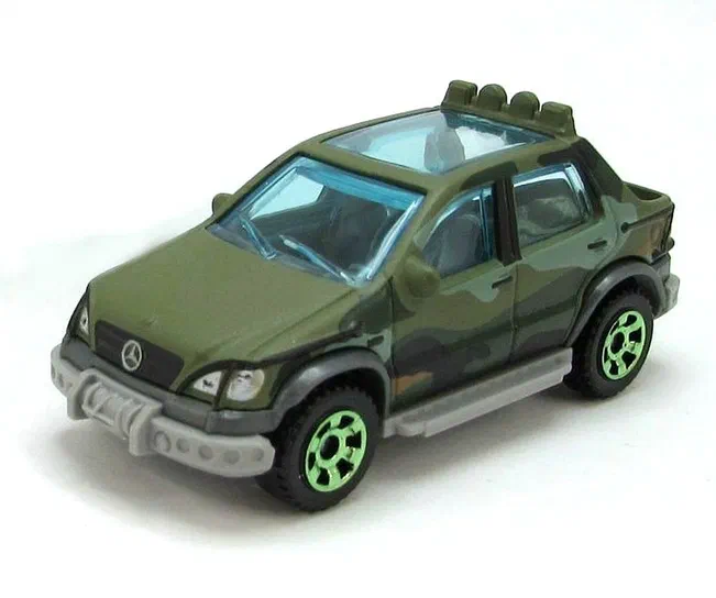 Miniature jouet verte à motifs camouflage et jantes vertes représentant une Mercedes-Benz ML 320 A.A.V. de la franchise Matchbox Jurassic World sur fond blanc.