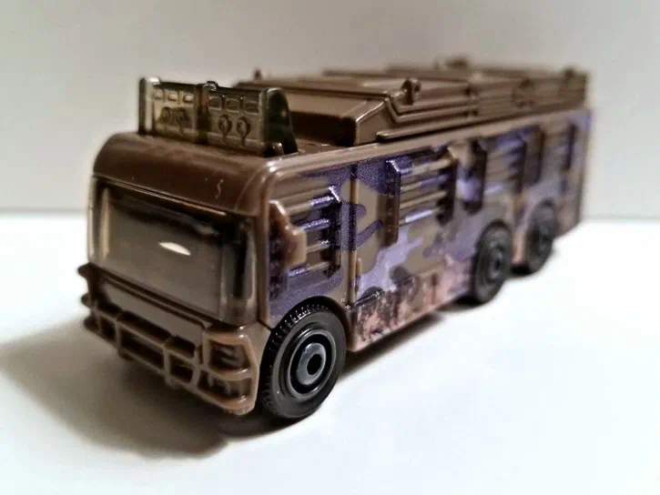 Puce Matchbox Fleetwood Southwind RV de la collection Jurassic World avec un camouflage marron et violet.