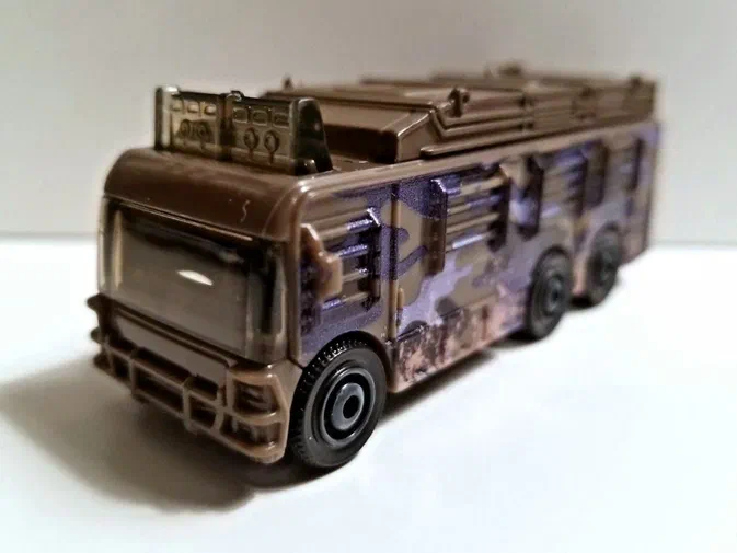 Puce Matchbox Fleetwood Southwind RV de la collection Jurassic World avec un camouflage marron et violet.