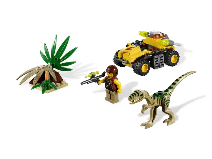 Ensemble LEGO Ambush Attack montrant une figurine d'explorateur armé face à un dinosaure beige et vert, avec un véhicule jaune tout terrain.