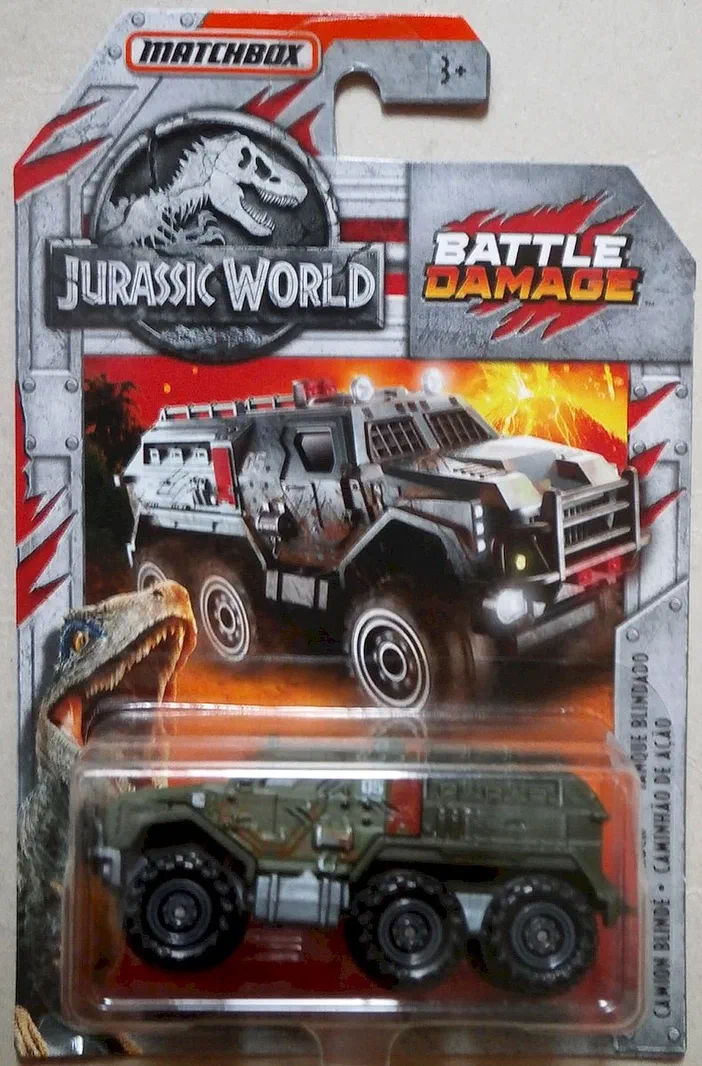 Véhicule de jouet camion blindé vert dans son emballage plastique, packaging illustrant le thème Jurassic World Battle Damage avec un dinosaure et les logos Matchbox et Jurassic Park