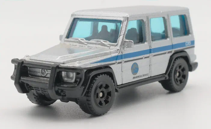 Voiture miniature blanche avec des bandes bleues et l'inscription 'FOR OFFICIAL USE ONLY', jouet Matchbox du film Jurassic World.