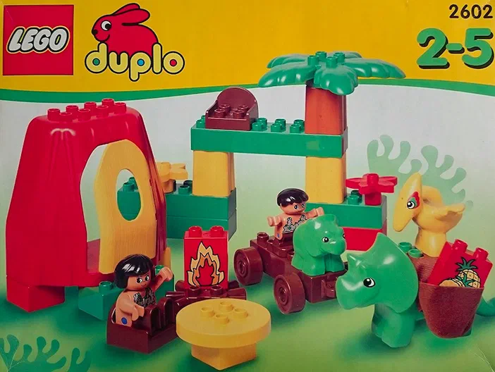 Jeu de construction LEGO DUPLO n°2602 Dinosaurs Family Home avec des dinosaures verts, un volcan rouge et deux personnages.