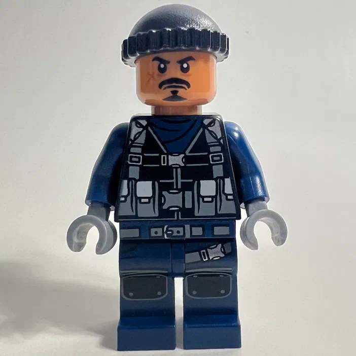 Minifigurine LEGO de gardien avec un chapeau noir, une moustache et des vêtements bleus.
