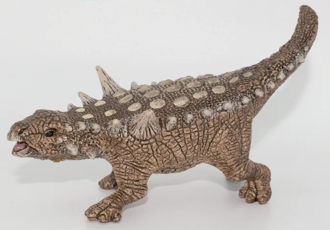 Modèle de dinosaure à dos épineux avec des plaques et une texture écailleuse sur fond blanc.