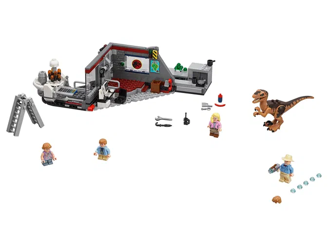 Ensemble de construction LEGO Jurassic World : une base avec un bureau et des panneaux muraux, accompagnée d'un dinosaure Velociraptor brun, plusieurs personnages minifigurines (dont un homme en chapeau), divers accessoires comme une radio ou une clé à molette, et quelques pièces détachées.