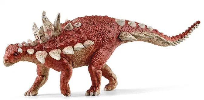 Un jouet de dinosaure Stegosaurus rouge avec des plaques blanches sur le dos et une longue queue.