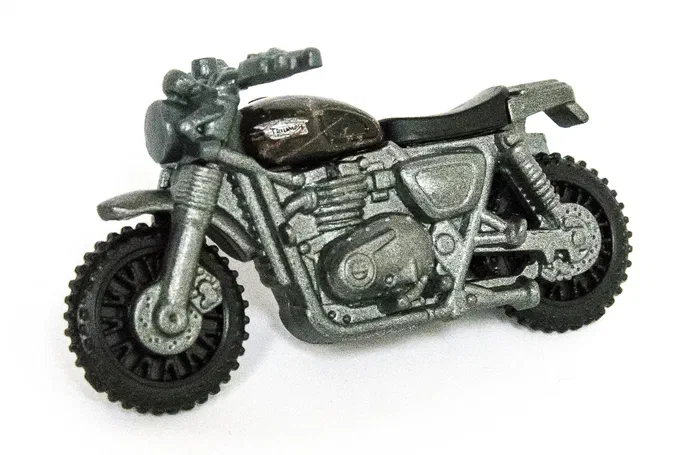 Jouet Matchbox d'une moto Triumph Scrambler de couleur olive vert avec des détails argentés et un réservoir noir.