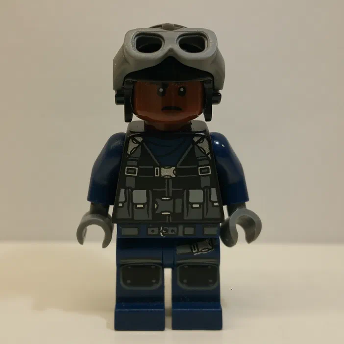 Minifigurine de gardien LEGO avec casque et lunettes, vêtue d'un uniforme bleu foncé.