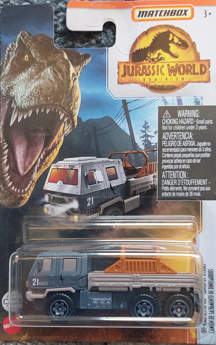 Camion de sauvetage Matchbox Jurassic World Dominion dans son emballage avec un T-Rex en arrière-plan