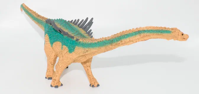 Jouet de dinosaure à long cou avec des écailles vertes et grises sur fond blanc.