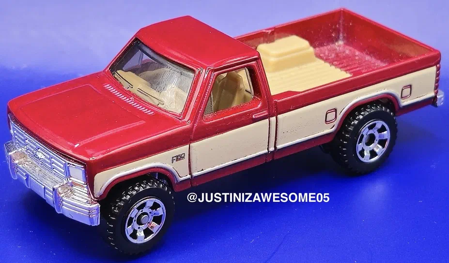 Puce Matchbox rouge et crème représentant un Ford F150 de 1986 sur fond bleu.