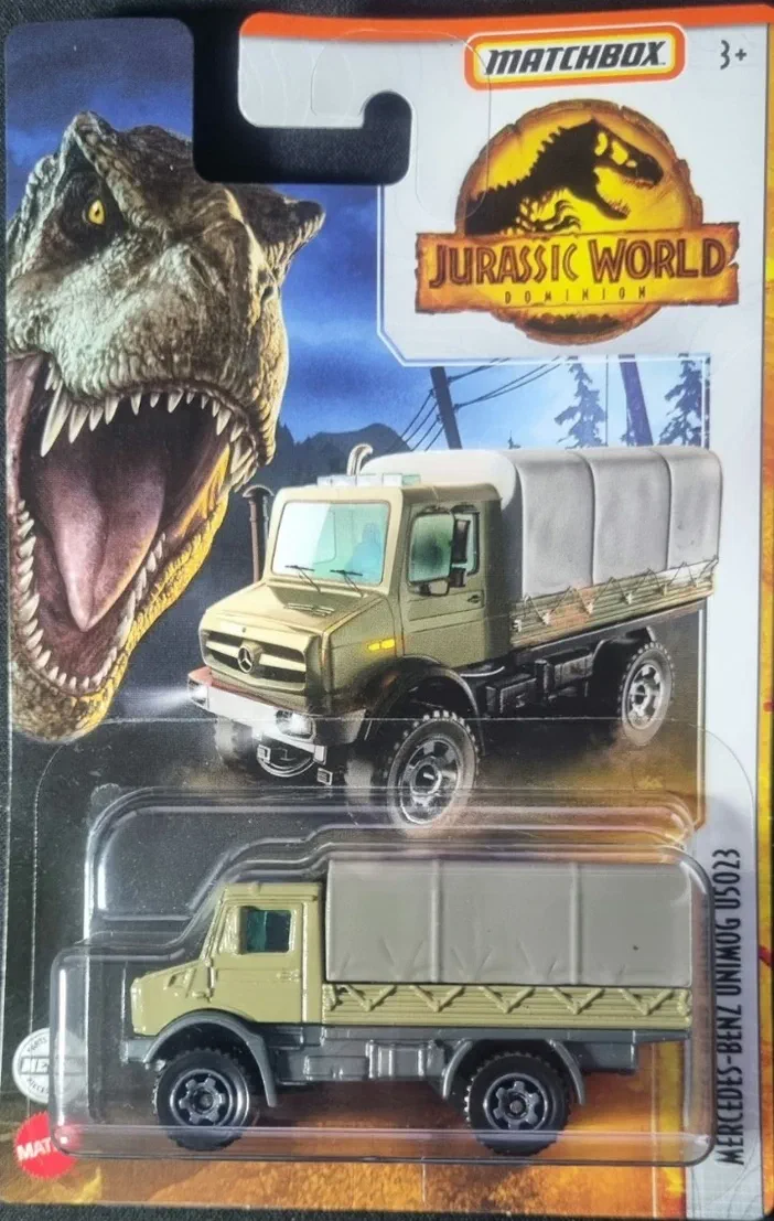 Camion de jouet Mercedes-Benz Unimog U5023 dans sa carte Matchbox Jurassic World Dominion avec un dinosaure en arrière-plan