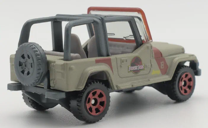 Un jouet Matchbox Jeep de Jurassic World avec un logo et le numéro 18 sur la portière.