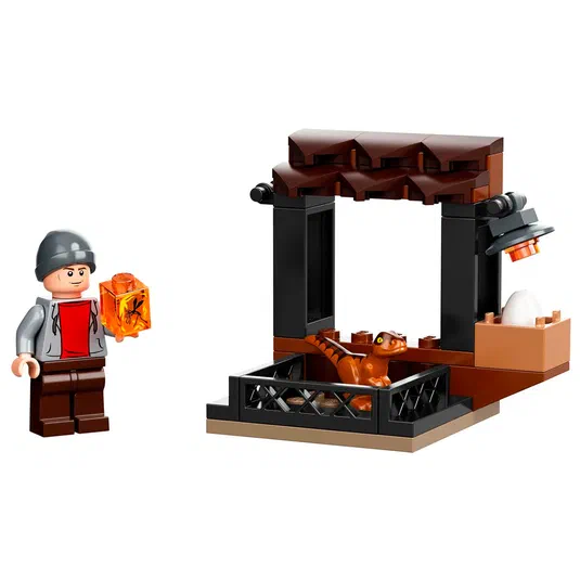 Ensemble de construction LEGO Jurassic World avec un minifigurine tenant une boîte orange et un dinosaure dans une cage.