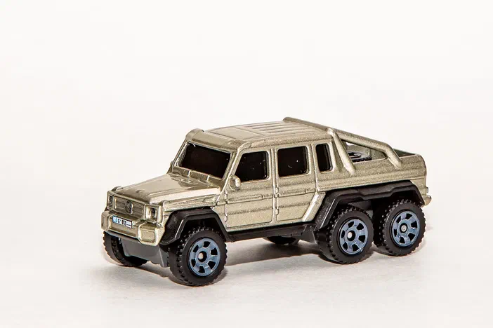 Voiture de collection Matchbox Mercedes-Benz G63 AMG 6x6 en beige métallique sur fond blanc.