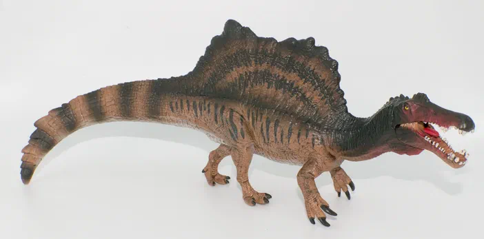 Maquette d'un dinosaure à crête dorsale sur fond blanc.
