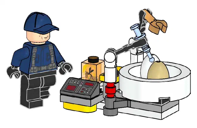 Un garde LEGO en bleu observe un incubateur contenant une dinosaure jaune, avec des écrans et un robot.