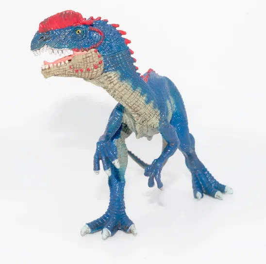 Figurine de dinosaure bleu avec des accents rouges et une texture détaillée sur fond blanc.