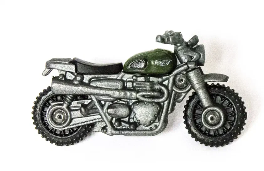 Miniature de moto Matchbox Triumph Scrambler avec réservoir vert olive et base argentée.