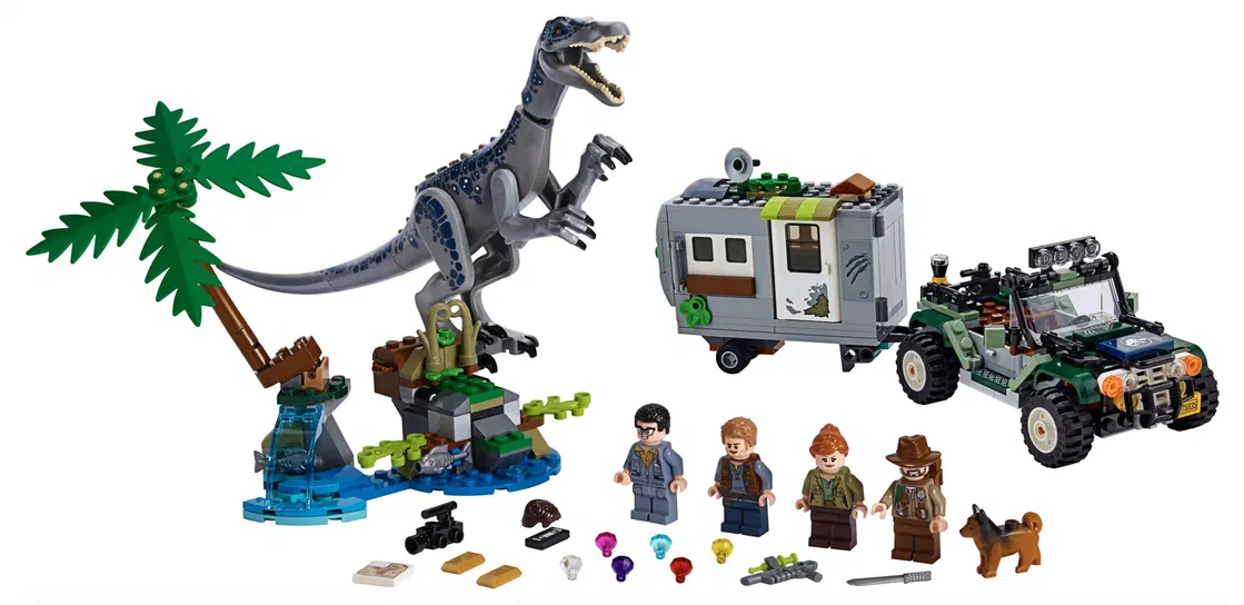 Ensemble de jeu LEGO Jurassic World avec un dinosaure Baryonyx gris et bleu sur une base bleue verte, un véhicule vert tirant une remorque grise, quatre personnages humains en costumes, un chien marron, des accessoires comme armes et outils.