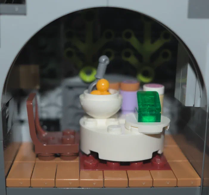 Vue d'un ensemble de pièces LEGO blanches et colorées disposées sur une base rouge dans un cadre circulaire.