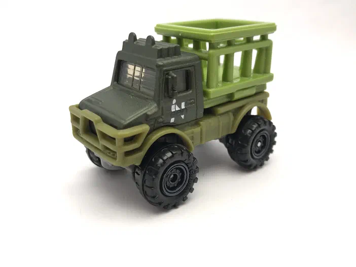 Puce Matchbox verte Mercedes-Benz Unimog U1300 avec benne, jouet de la série Jurassic World Rebirth.