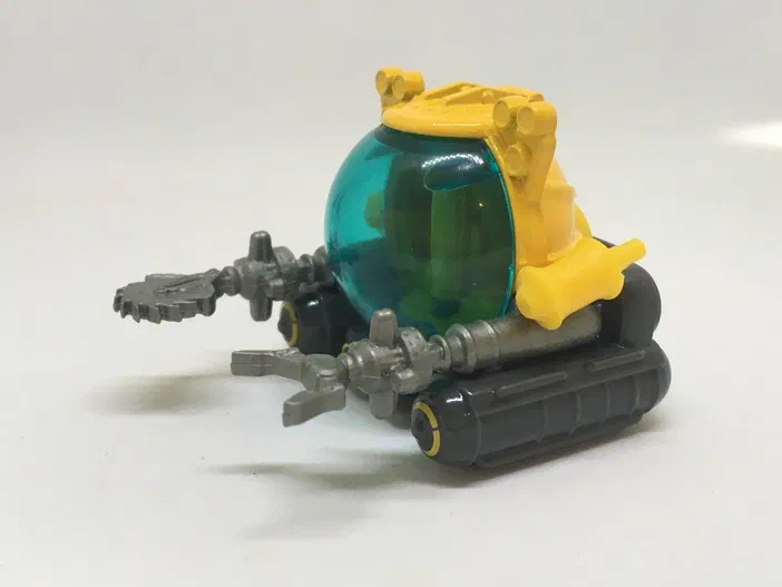Un sous-marin jouet Matchbox jaune et bleu avec des chenilles grises.