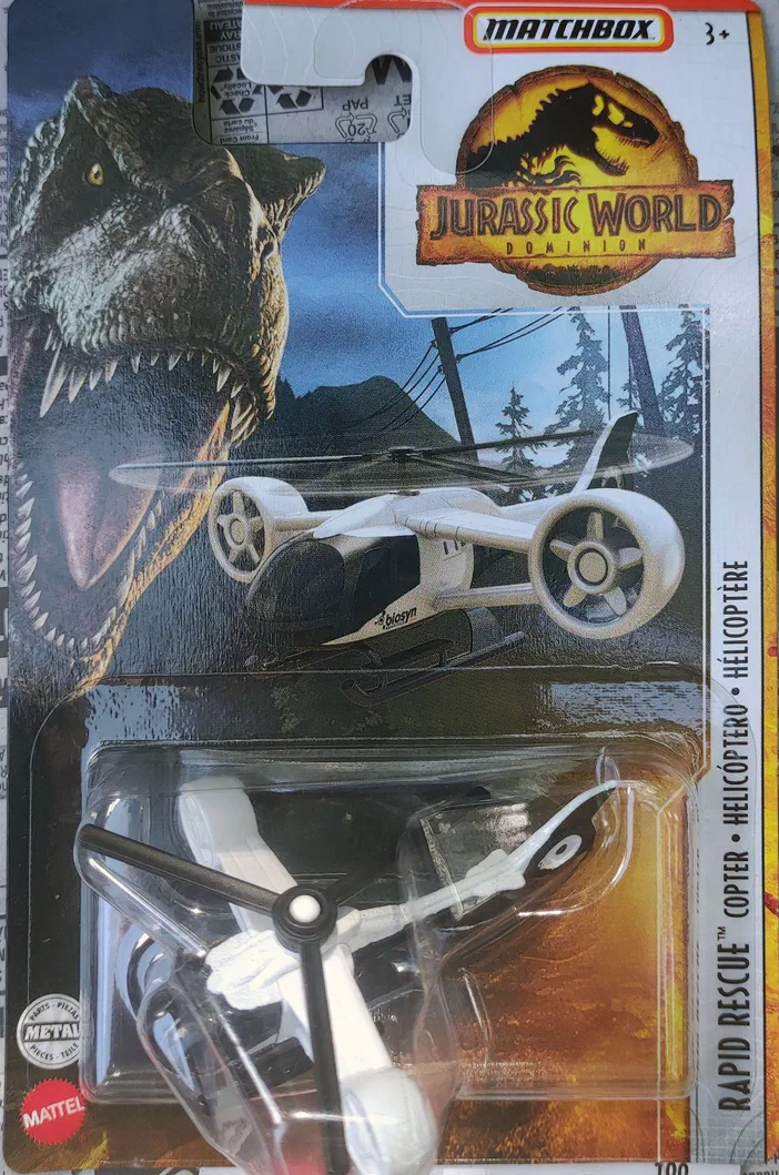 Un hélicoptère blanc Matchbox Rapid Rescue Copter de la collection Jurassic World Dominion est emballé dans son blister avec un T-Rex en arrière-plan.