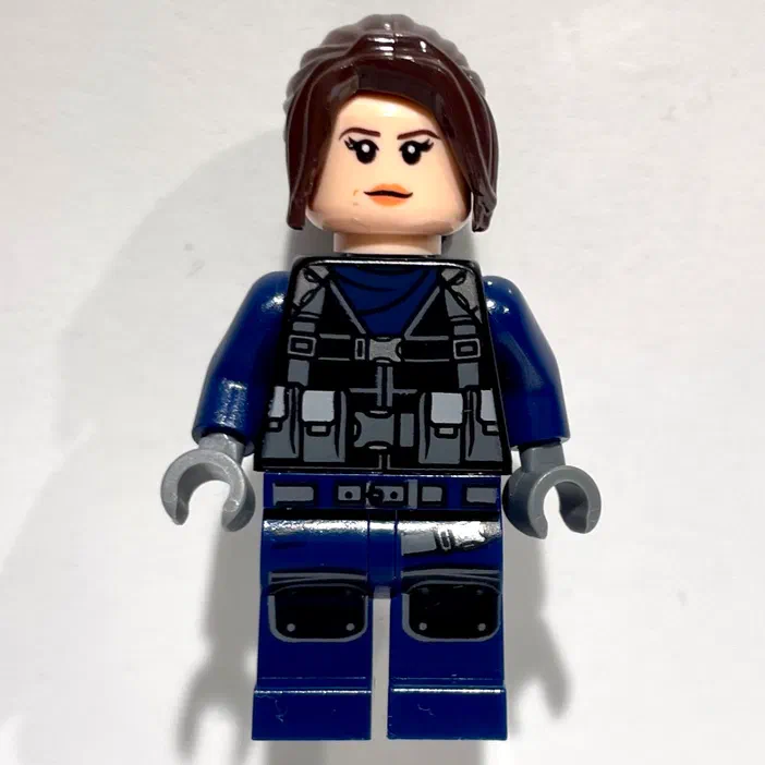 Minigurkin LEGO de la série Jurassic World : une gardienne féminine avec un uniforme bleu et noir.