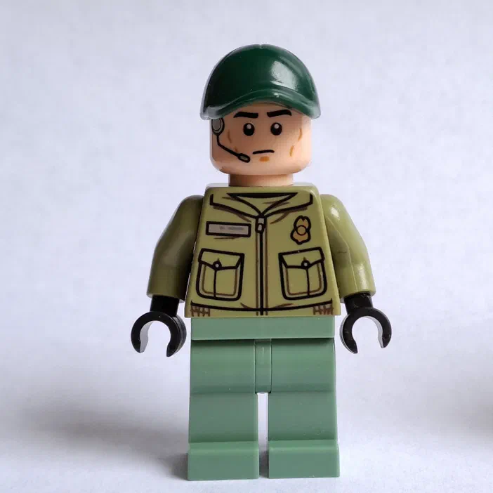 Minifigurine LEGO de Jurassic World avec un casque vert et une veste beige.