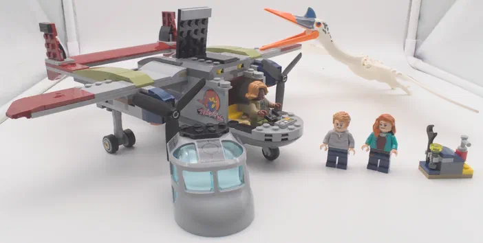 Un ensemble de figurines LEGO Jurassic World incluant un avion, une créature volante et deux personnages.
