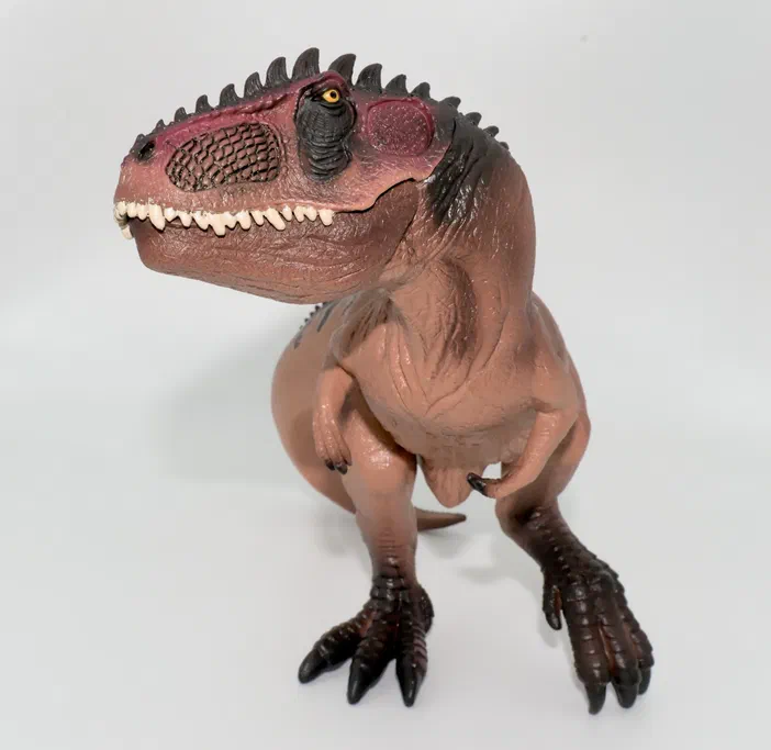 Figurine de dinosaure T-Rex en position debout sur fond blanc.