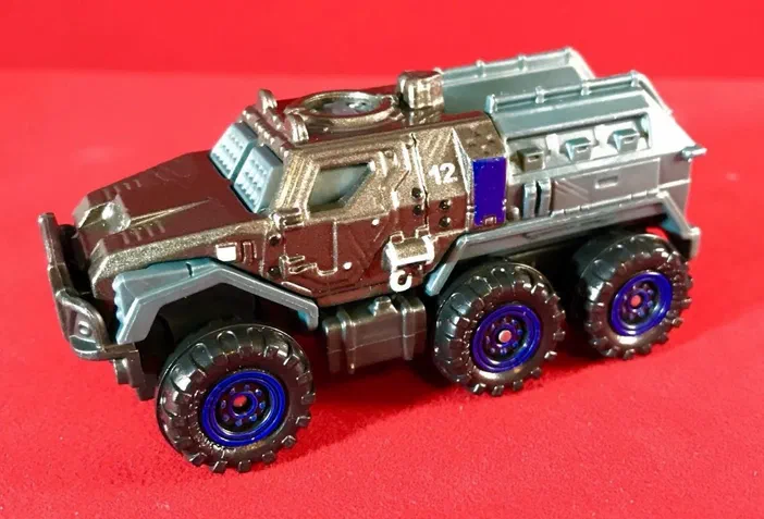 Camionnette blindée Matchbox Armored Action Truck (2018) sur fond rouge