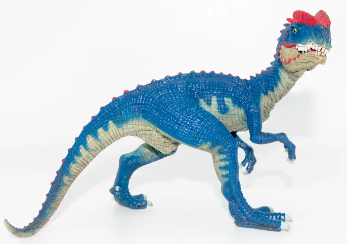 Un jouet de dinosaure bleu avec des crêtes rouges et une texture écailleuse.