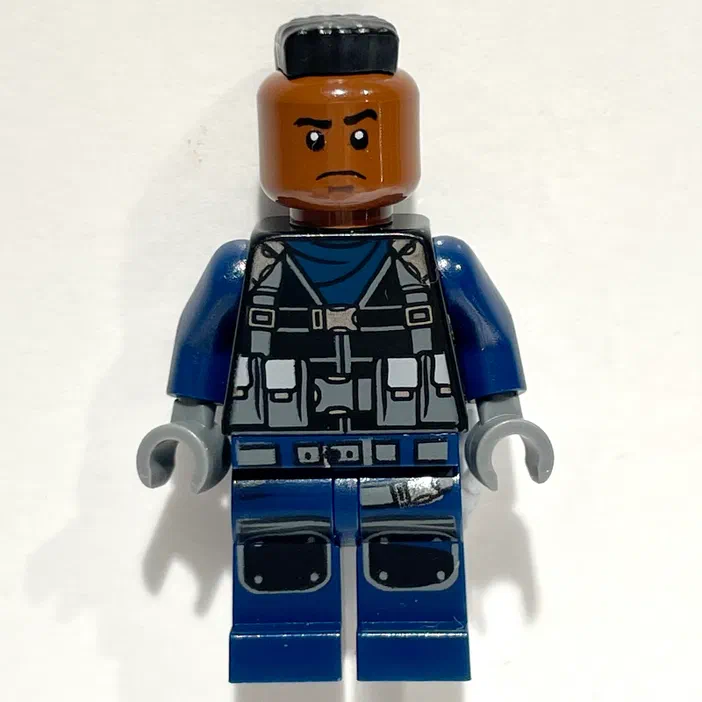 Minigurka LEGO Tracker avec une coiffure mohawk et un gilet de survêtement bleu.