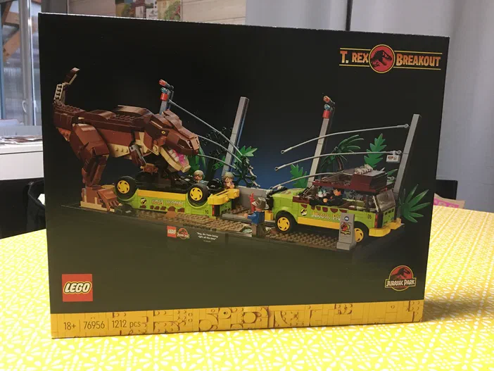 Boîte du set LEGO Jurassic World T-Rex Breakout (référence 76956) montrant un dinosaure et des véhicules sur fond noir.