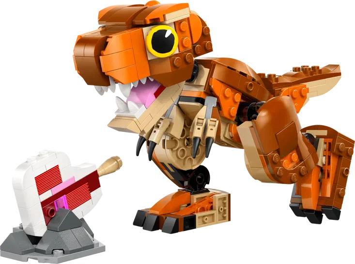 Un dinosaure T-Rex en briques LEGO orange et beige, avec une mâchoire ouverte montrant des dents blanches et un cœur rouge cassé sur un socle gris à gauche.