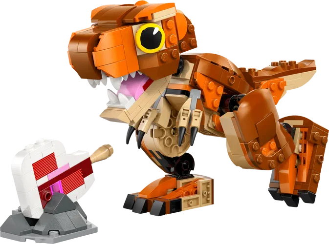 Un dinosaure T-Rex en briques LEGO orange et beige, avec une mâchoire ouverte montrant des dents blanches et un cœur rouge cassé sur un socle gris à gauche.