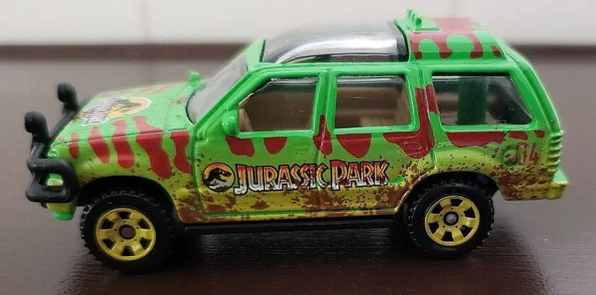 Petite voiture Matchbox Ford Explorer verte avec des rayures rouges et le logo Jurassic Park sur les flancs.