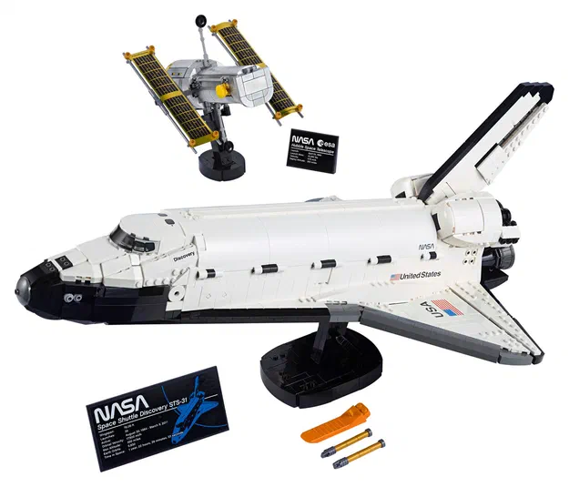 Un modèle de fusée spatiale LEGO blanc et noir avec des panneaux solaires jaunes, accompagné d'une étiquette NASA.