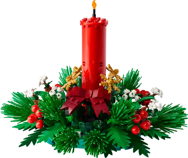 Décoration de table pour Noël en LEGO avec une bougie rouge, des feuilles vertes et des baies rouges.