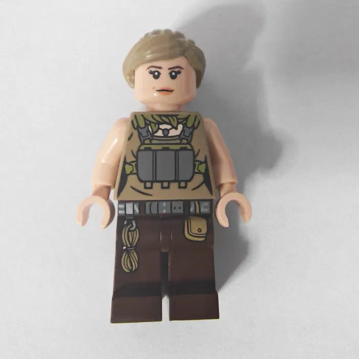 Minifigurine LEGO de Jurassic World, avec une veste beige et un sac à dos vert.