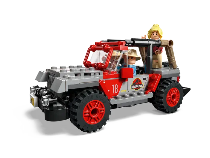 Voiture rouge et grise du jeu LEGO Jurassic World avec trois personnages minifigurines à bord.