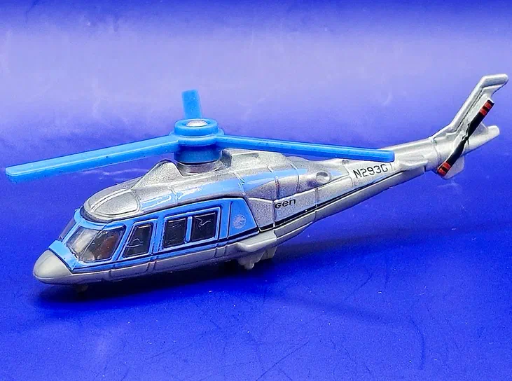 Hélicoptère de jouet Matchbox InGen AW109 argent avec rotor bleu sur fond violet