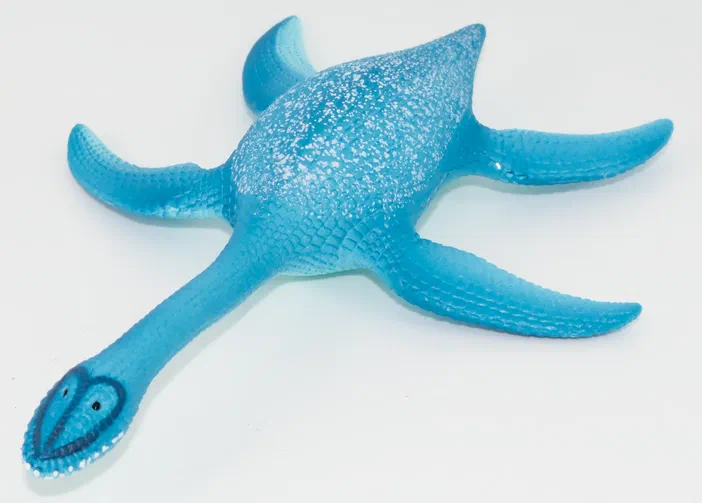 Jouet bleu représentant un dinosaure à long cou avec des nageoires et une texture écailleuse sur fond blanc.