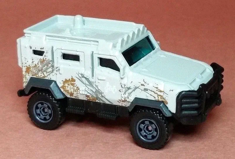 Petit camion Matchbox Textron Tiger blanc avec des traces de boue et d'écraies gris simulées sur le côté.