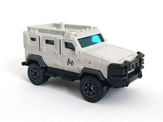 Voiture jouet Matchbox Textron Tiger beige avec des détails noirs et une inscription InGen sur le côté.